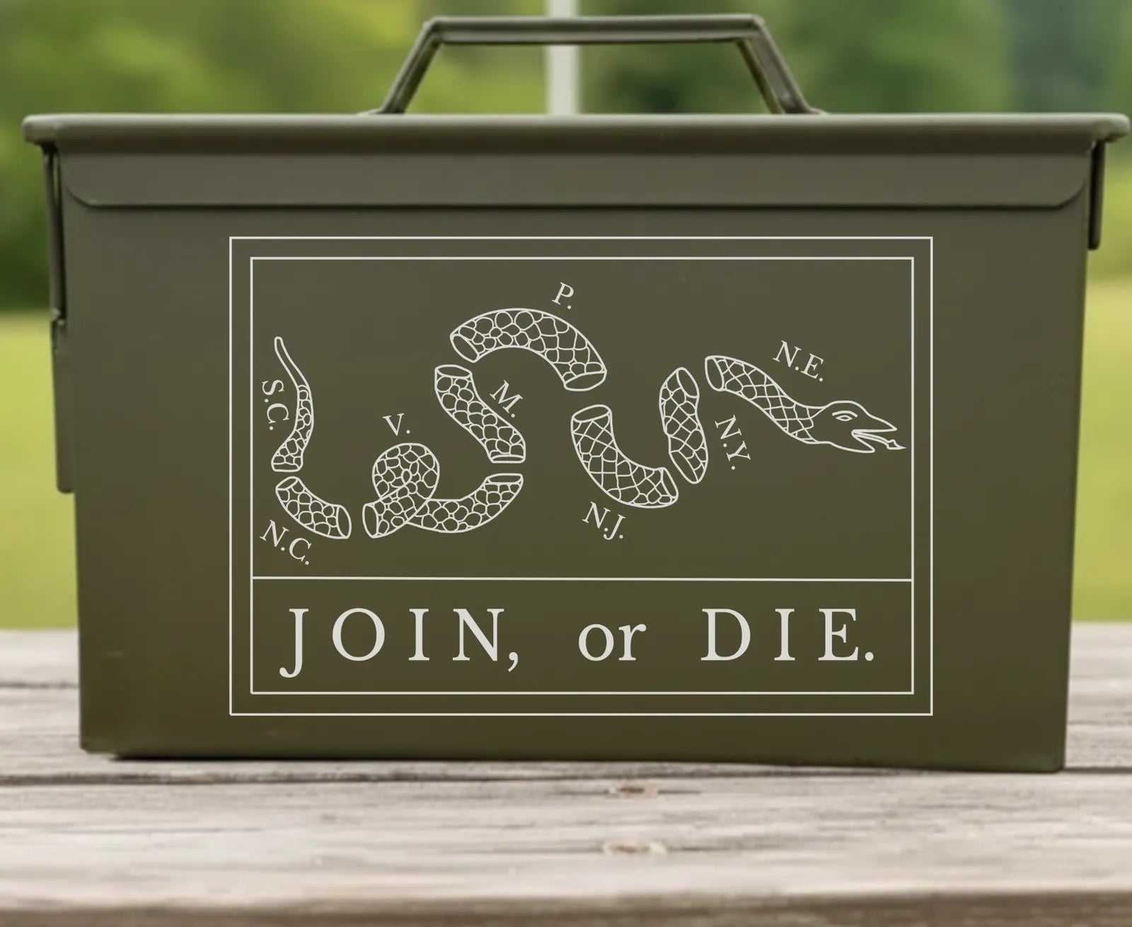 Front of the Join Or Die engraved ammo can: a snake cut in eight lettered pieces over JOIN, or DIE.